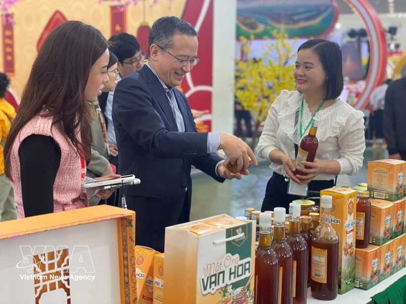 Chief representative Ozasa Haruhiko (centre) of the JETRO Office in Hanoi visits a booth at the first Glorious Spring Fair on February 6. (Photo: VNA)
