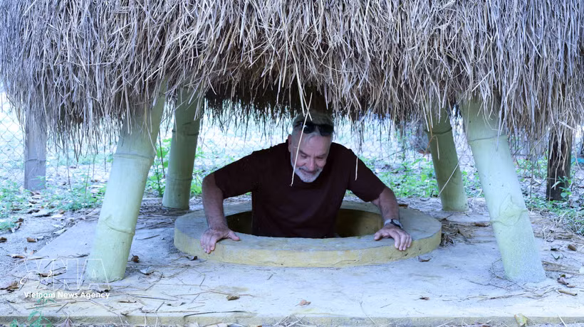 A visitor at a tunnel entrance located within a resident’s garden at the Ky Anh Tunnels. (Photo: VNA)