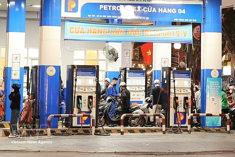 Motorcycle riders refill their vehicles at a petrol station in Hanoi (Photo: VNA)