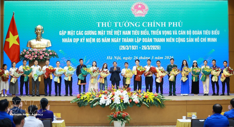 Prime Minister Pham Minh Chinh presents flowers to outstanding young people. (Photo: VNA)