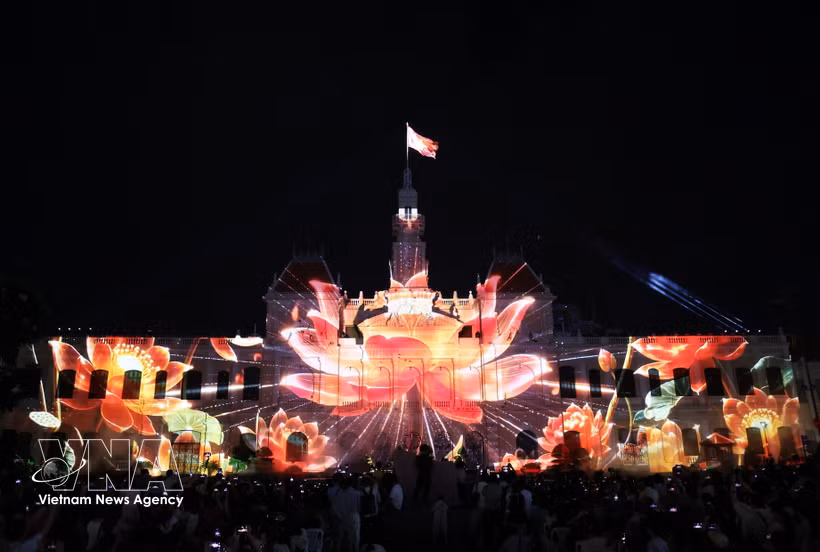 The lotus – a symbol of Vietnamese beauty and cultural identity – is recreated through 3D mapping technology across the façade of the Ho Chi Minh City People’s Committee headquarters on July 1, 2026. (Photo: VNA)