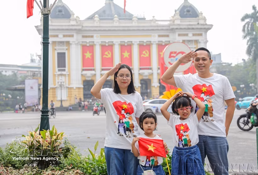 A family pose for a picture in Hanoi marking the 50th anniversary of the Liberation of the South and National Reunification (April 30, 2025) (Photo: VNA)
