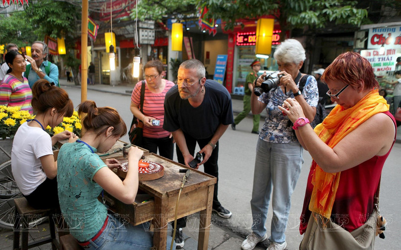 Tourists experience silver craft in Hang Bac street of Hanoi (Photo: VNA)
