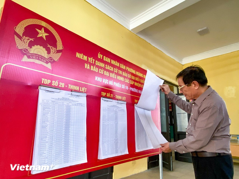 A voter carefully learns about candidates before the Election Day. (Photo: VNA)