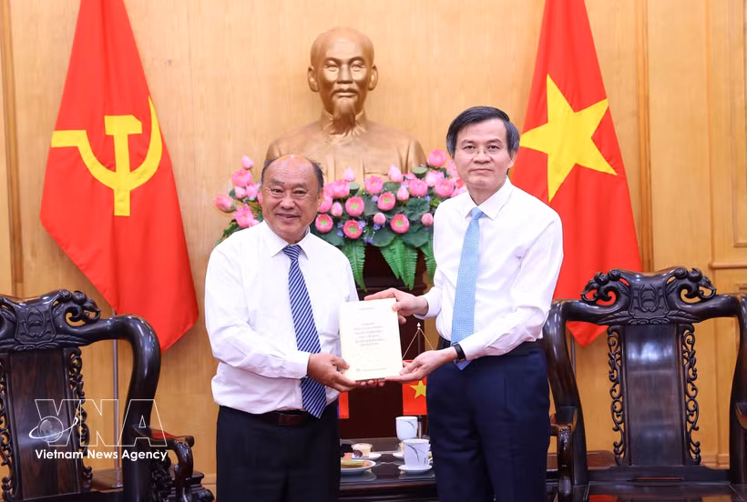 President of the Ho Chi Minh National Academy of Politics Assoc. Prof. Dr Doan Minh Huan (R) presents a book to President of the Lao Academy of Social and Economic Sciences Leeber Leebouapao at their meeting in Hanoi on May 26. (Photo: VNA)