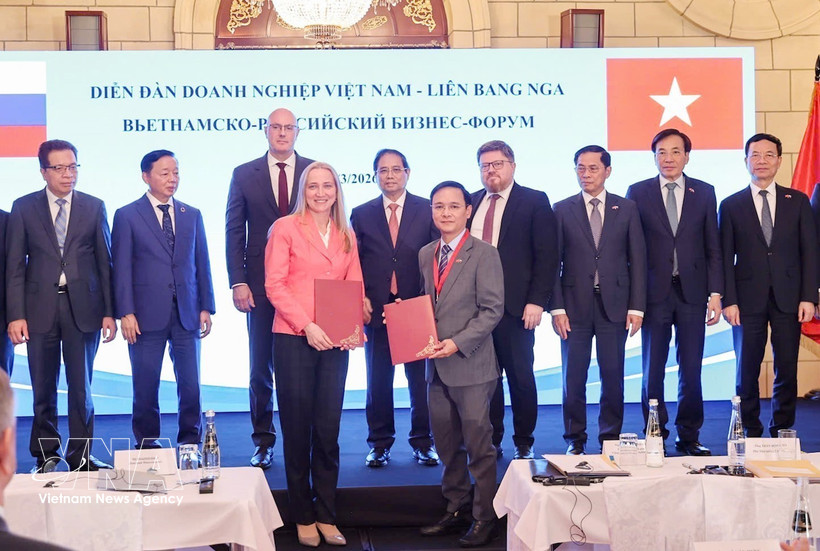 Prime Minister Pham Minh Chinh and officials witness the exchange of cooperation documents between Vietnamese and Russian businesses at the Vietnam – Russian Federation Business Forum in Moscow on March 24. (Photo: VNA)