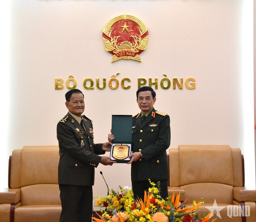 Minister of National Defence Gen. Phan Van Giang (R) hands over a gift to Secretary of State at the Cambodian Ministry of National Defence Gen. Prum Din at their meeting in Hanoi on March 9 (Photo: qdnd.vn)