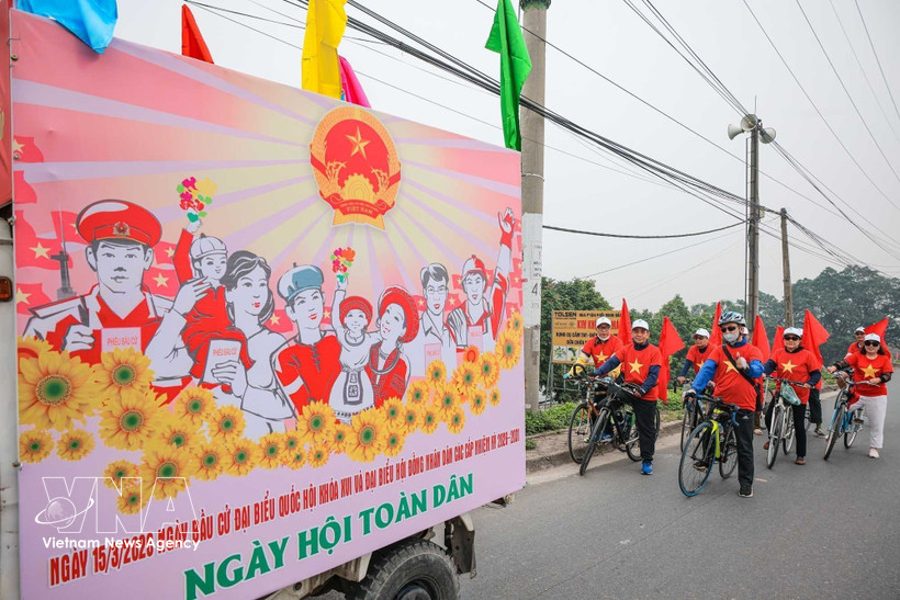 A communication team of O Dien commune in Hanoi cycle to support the general election. (Photo: VNA)