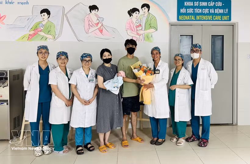 Medical staff from Da Nang Hospital for Women and Children present flowers to congratulate the couple and their baby on the child’s discharge from hospital. (Photo published by VNA)