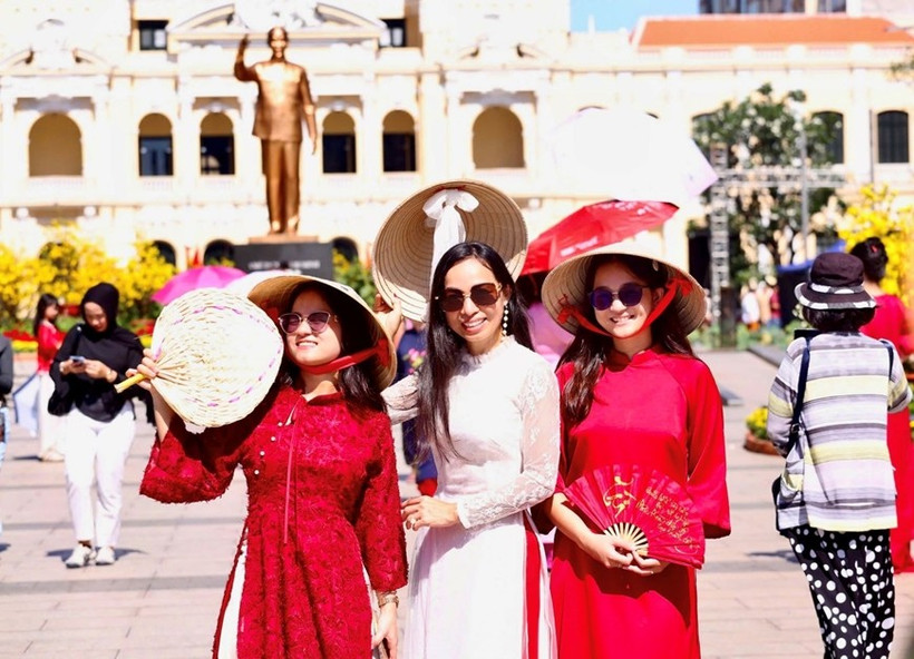 Overseas Vietnamese in traditional ao dai explore Nguyen Hue flower street. (Photo: qdnd.vn)