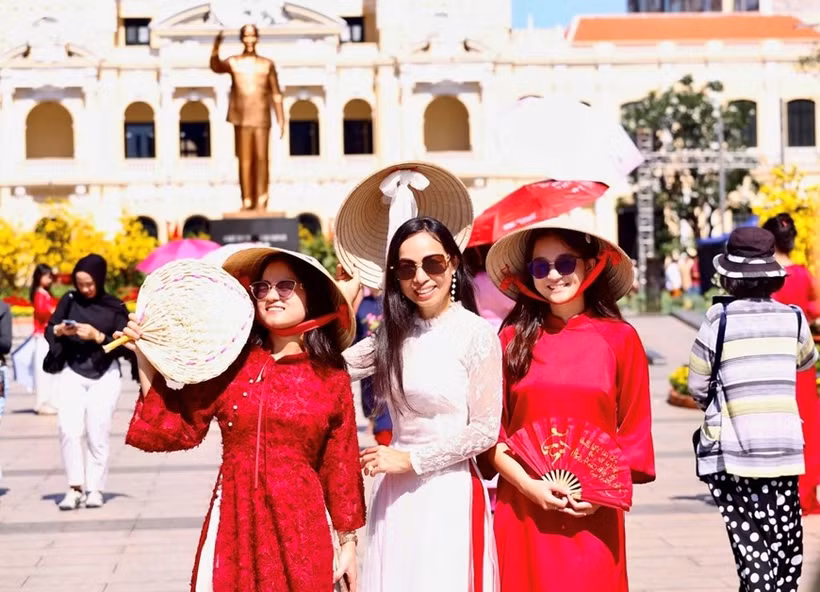 Overseas Vietnamese in traditional ao dai explore Nguyen Hue flower street. (Photo: qdnd.vn)