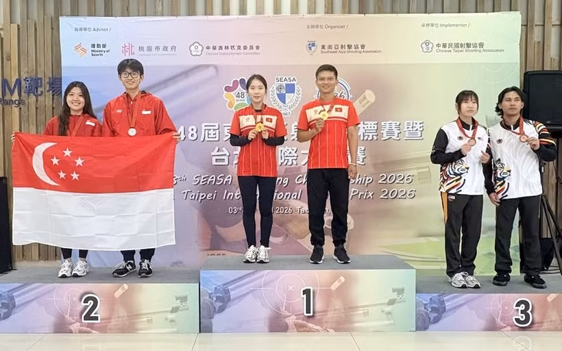 Gold medallists Le Thi Mong Tuyen and Nguyen Thanh Nam celebrate on the podium. (Photo: qdnd.vn)