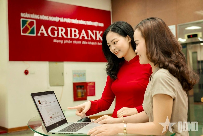 An Agribank staff instructs a customer to conduct safe digital transactions (Photo: qdnd.vn)