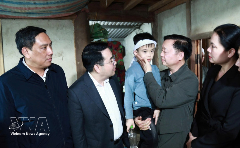 Deputy Prime Minister Tran Hong Ha (second, right) visits the child who survived in the accident. (Photo: VNA)