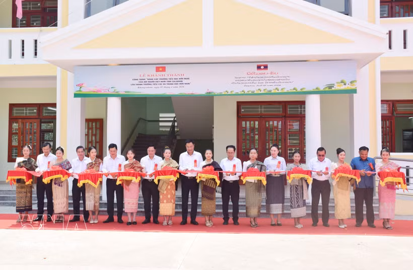 Representatives from both countries cut the ribbon to inaugurate the Friendship Primary and Secondary School in Salavan province of Laos (Photo: VNA)