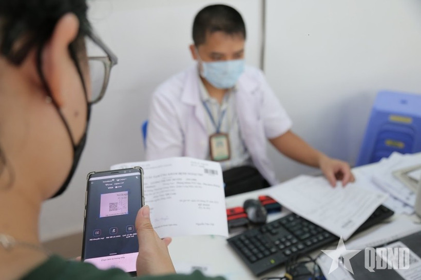 A patient pays hospital fees using cashless transactions (Photo: qdnd.vn)