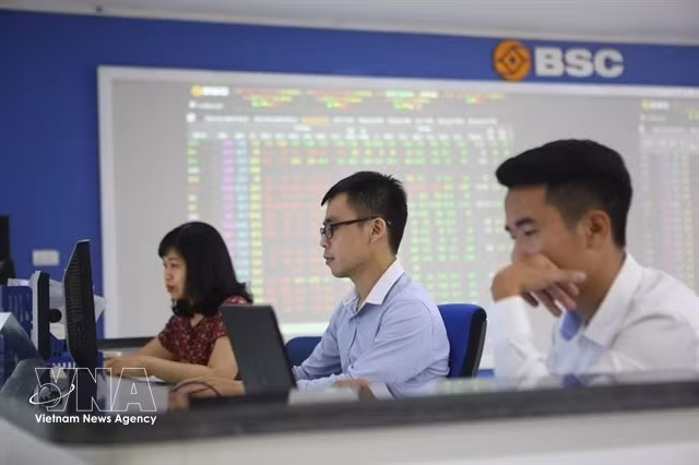 Traders work on a trading floor of a securities firm. (Photo: VNA)
