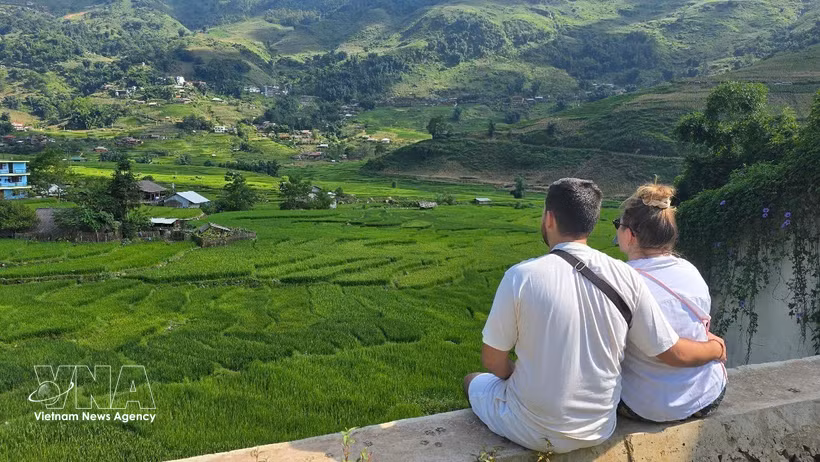 Foreign tourists enjoy the lush green rice fields in Ta Van commune, Lao Cai province. (Photo: VNA)