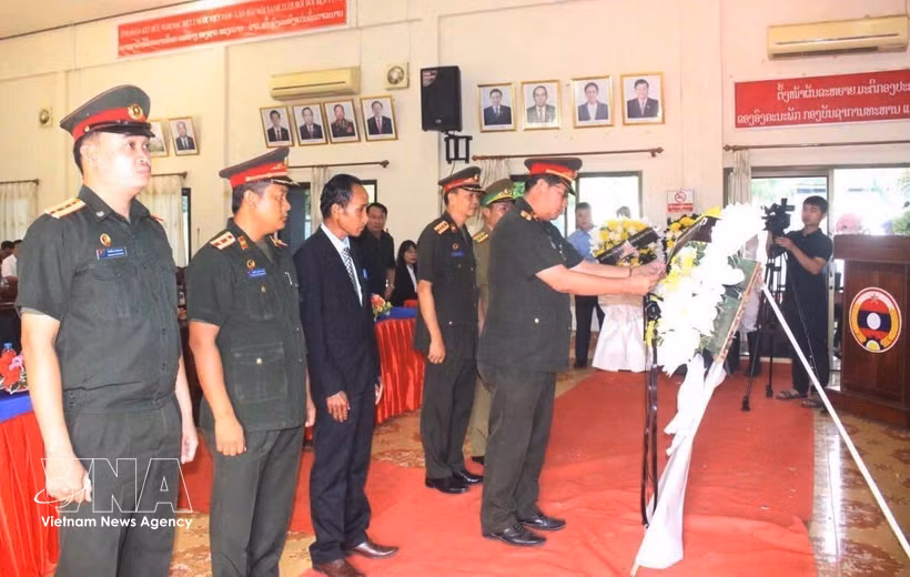 Representatives of the armed forces of southern Lao provinces offer flowers at the ceremony. (Photo: VNA)