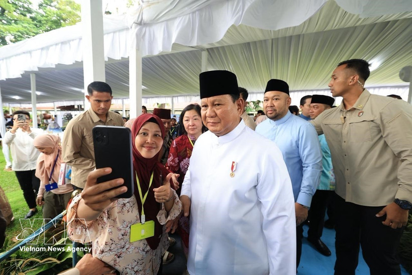 Indonesian President Prabowo Subianto poses for a photo with a visitor to the Presidential Palace of Indonesia in Jakarta. (Photo: VNA)