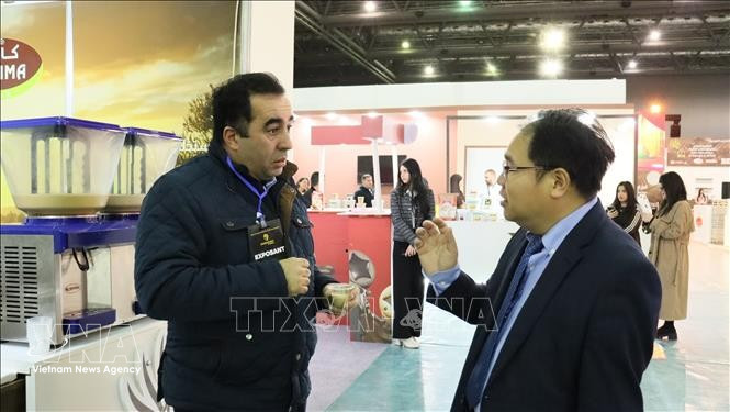 Hoang Duc Nhuan – Trade Counselor of Vietnam in Algeria, discusses with a representative of an Algerian company exporting carbob powder to Vietnam (Photo: VNA)
