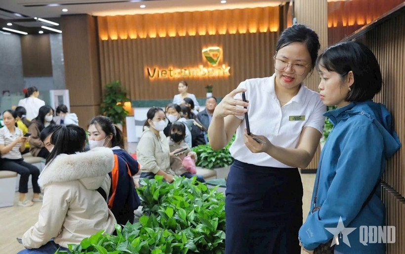 A Vietcombank employee guides a client in biometric process (Photo: qdnd.vn)