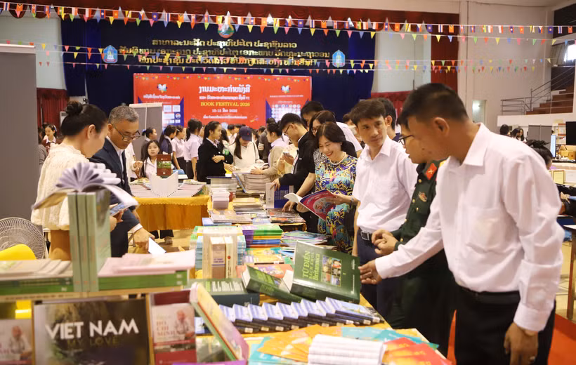 Delegates visit the book display booth of the Vietnamese Embassy in Laos. (Photo: VNA)