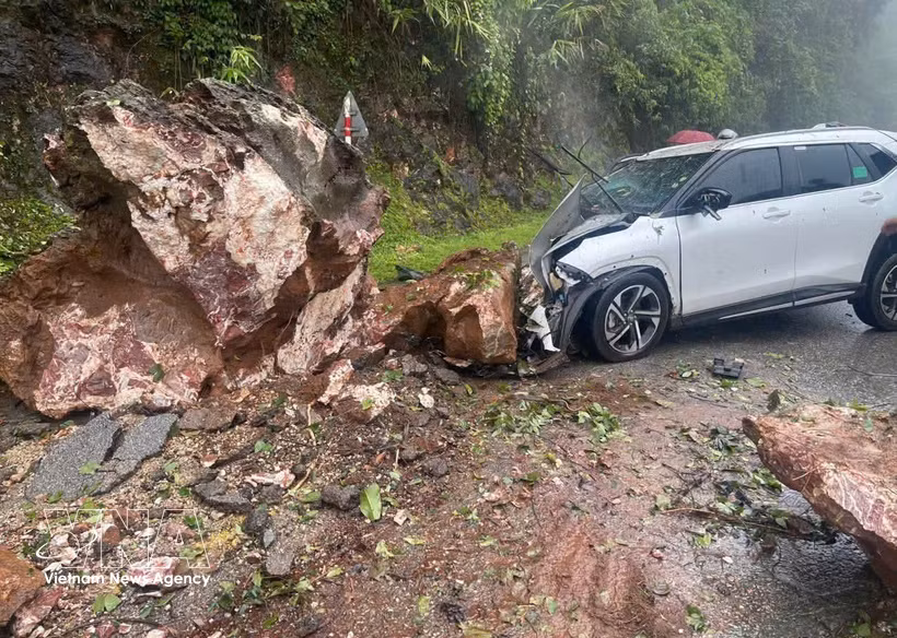 Prolonged heavy rain caused a landslide that sent rocks falling onto a car traveling on the road at Cao Pha slope, Muong Bu commune, Son La province. (Photo published by VNA)
