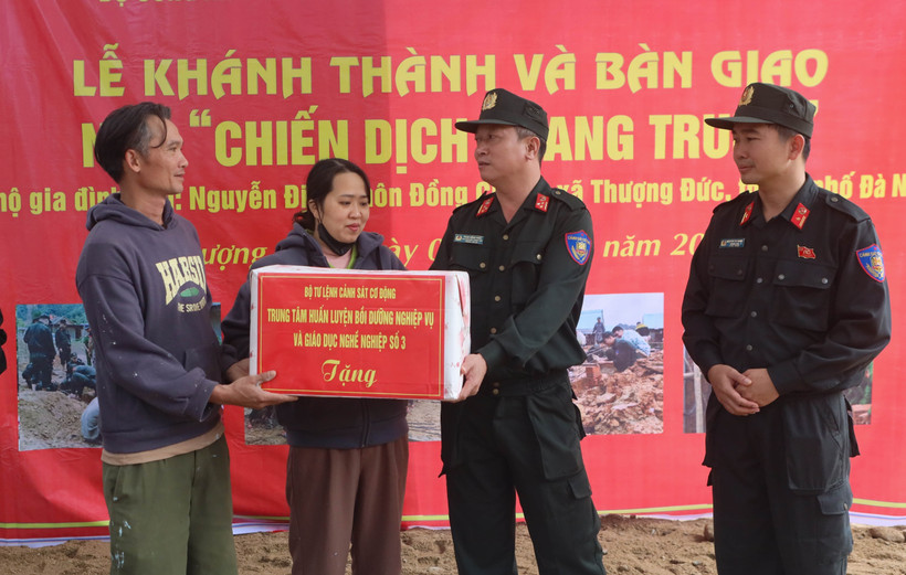 Lieutenant Colonel Pham Hong Phuc (right) from Mobile Police Command congratulates a couples in Thuong Duc commune, Da Nang city, on their new house built by the police force. (Photo: VNA)