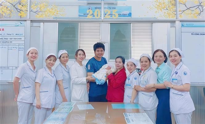 The newborn is discharged from hospital, delighting the family and medical team. (Photo published by VNA)