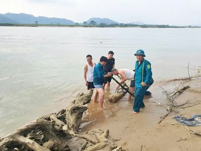 Authorities lift the bomb from the Lam River bank for disposal. (Photo: baomoi.com)
