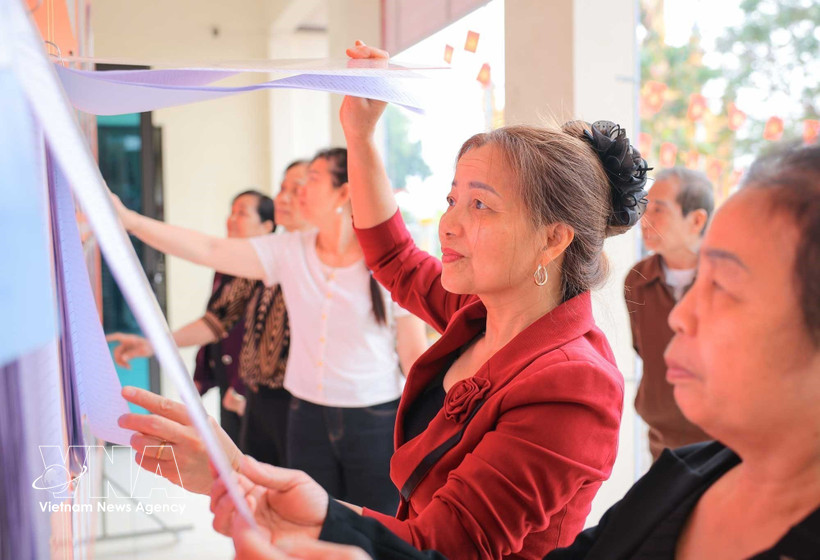 People read information about candidates at polling station No. 6 in Hanoi. (Photo: VNA)