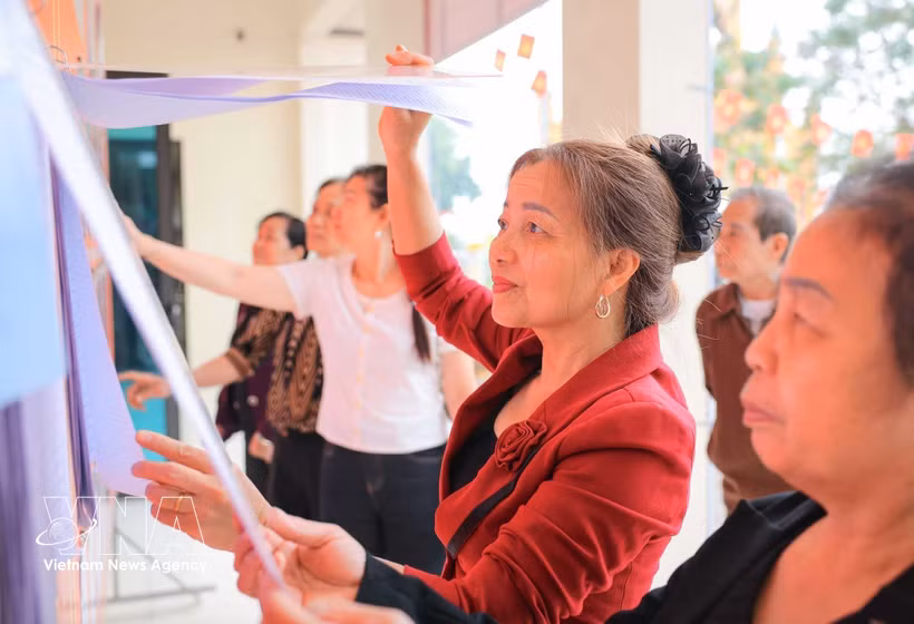 People read information about candidates at polling station No. 6 in Hanoi. (Photo: VNA)