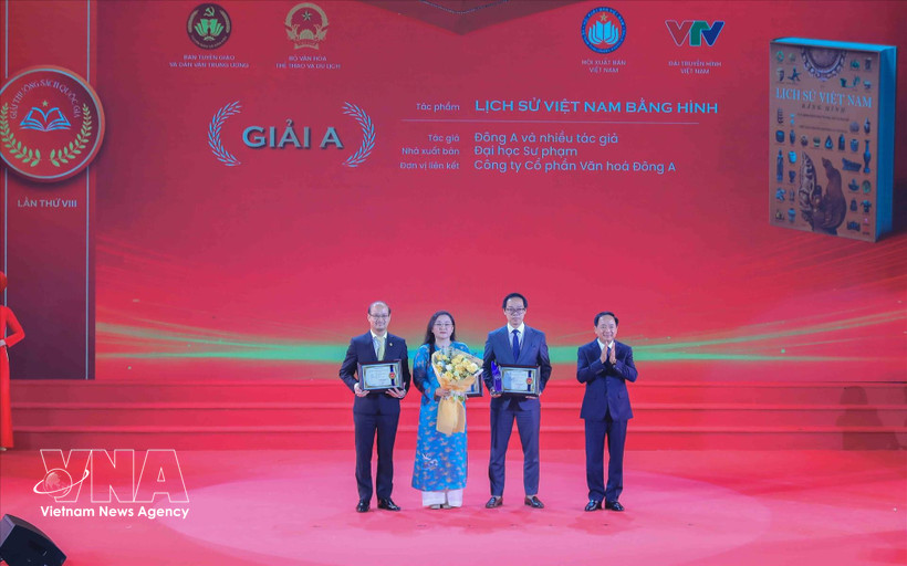 Head of the Party Central Commitee's Commission for Information, Education and Mass Mobilisation Trinh Van Quyet (first, right) presents A prize to the winning authors and groups of authors. (Photo: VNA)