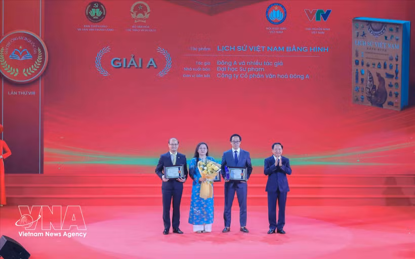 Head of the Party Central Commitee's Commission for Information, Education and Mass Mobilisation Trinh Van Quyet (first, right) presents A prize to the winning authors and groups of authors. (Photo: VNA)