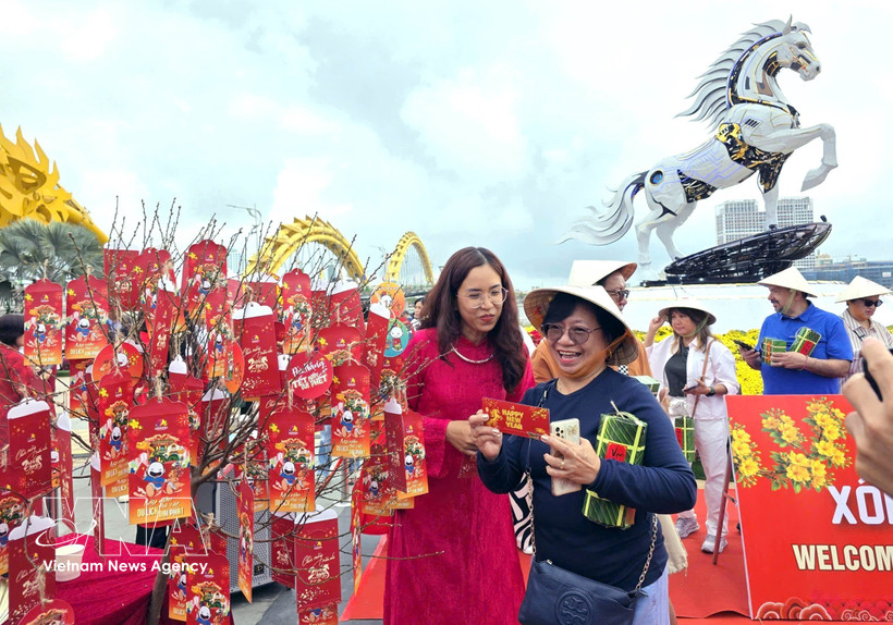 International tourists presented with New Year lucky money. (Photo: VNA)