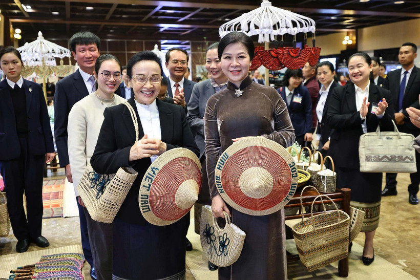 Ngo Phuong Ly (R), spouse of the Vietnamese Party General Secretary, and visiting Naly Sisoulith, spouse of the Lao Party General Secretary and President, take part in an exchange with outstanding artisans from several traditional craft villages of Ninh Binh province on January 27. (Photo: VNA)