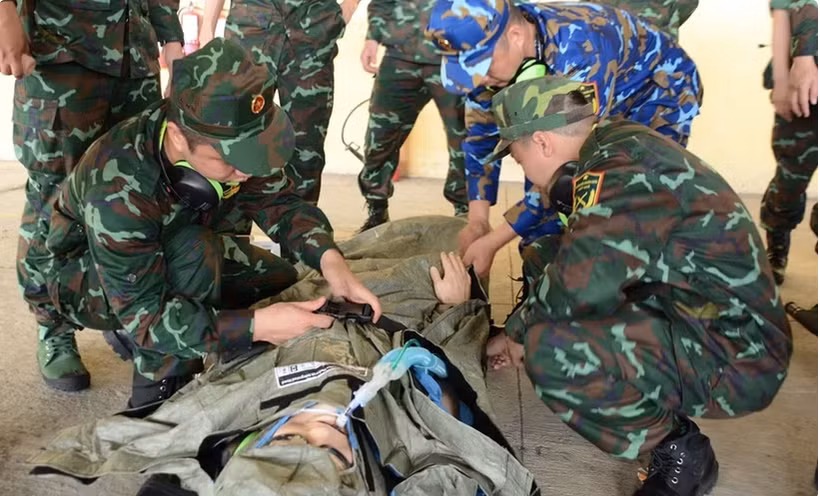 AMET members practise receiving and securing a patient on a stretcher in preparation for transport to an ambulance (Photo: VNA)
