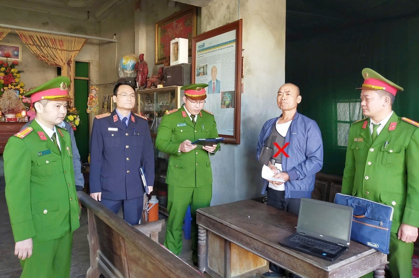 A policeman reads an order to detain Le Minh Vu (Photo: VNA)
