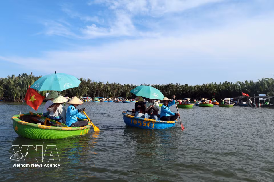 International visitors enjoy drifting along on small basket boats at Cam Thanh coconut village. (Photo: VNA)