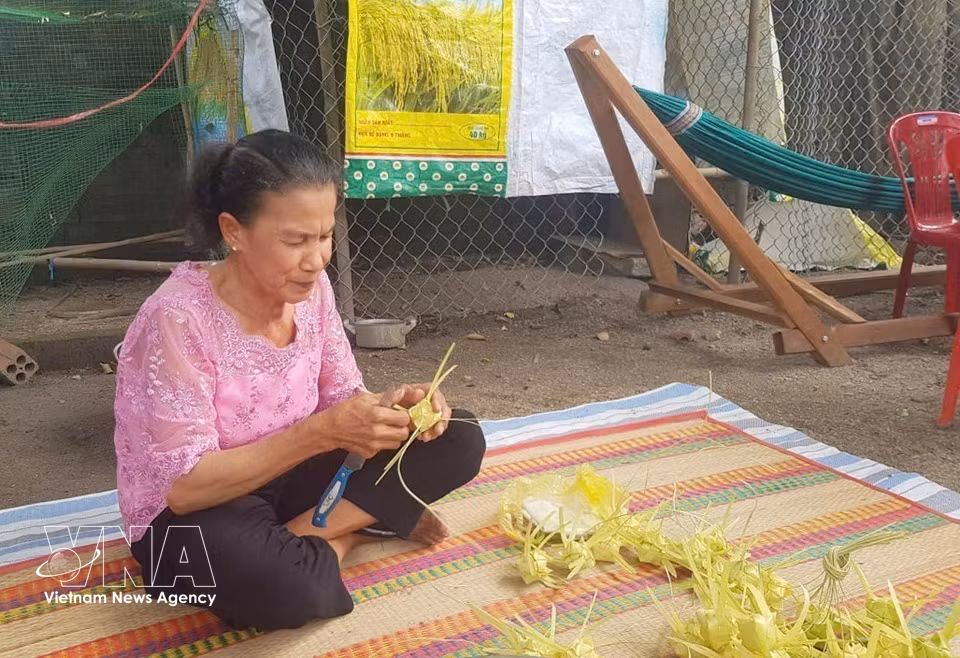 Artisan Neang Phuong meticulously weaves each Ka Tum cake casing, showcasing the dexterity and artistry of Khmer women. (Photo: VNA)
