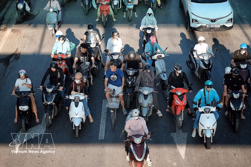 Not even 7 AM yet, but the streets of Hanoi have already been crowded with people and vehicles trying to avoid the intense heat of the day. (Photo: VNA)