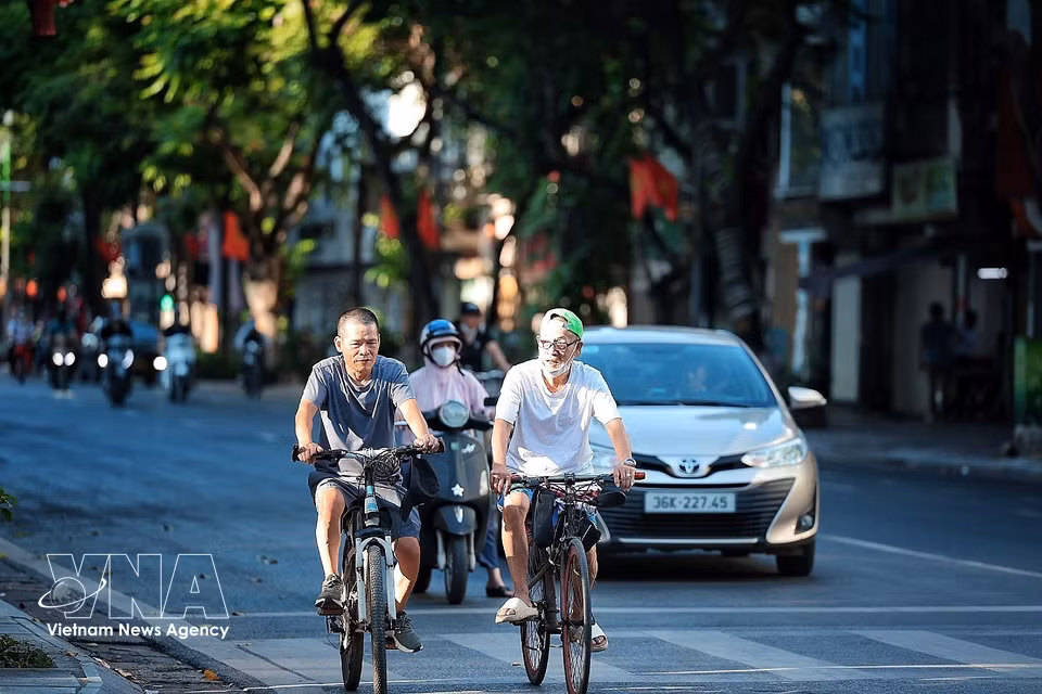 People go out cycling for exercise early in the morning, returning home earlier than usual. (Photo: VNA)