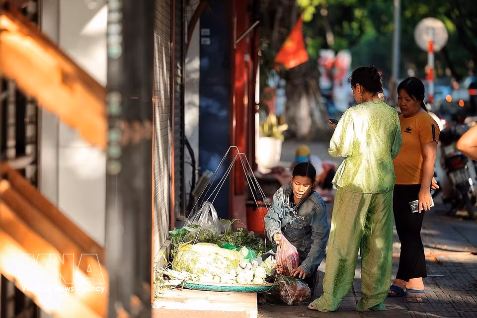 From early morning, many people go to the market to buy food and vegetables. (Photo: VNA)