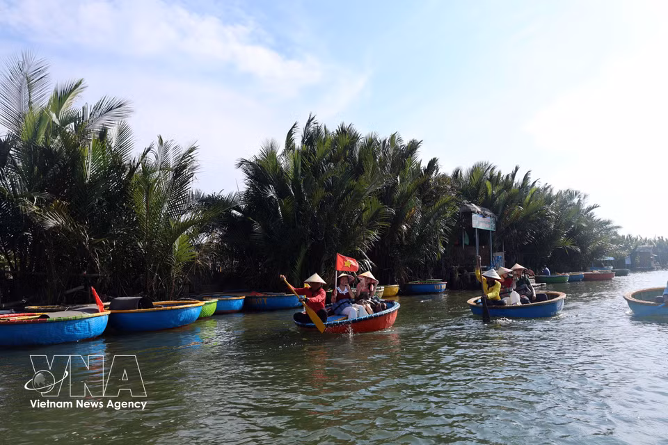 Local residents re-enact traditional net-casting fishing activities for visitors at Cam Thanh coconut village. (Photo: VNA)