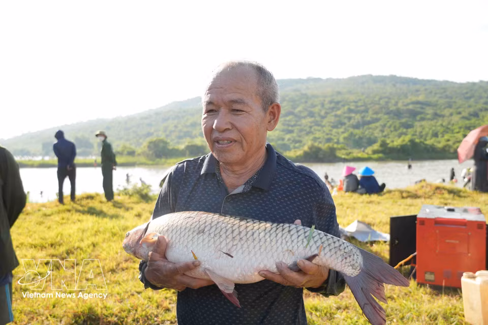 A participant displays the day’s catch at the festival. (Photo: VNA)