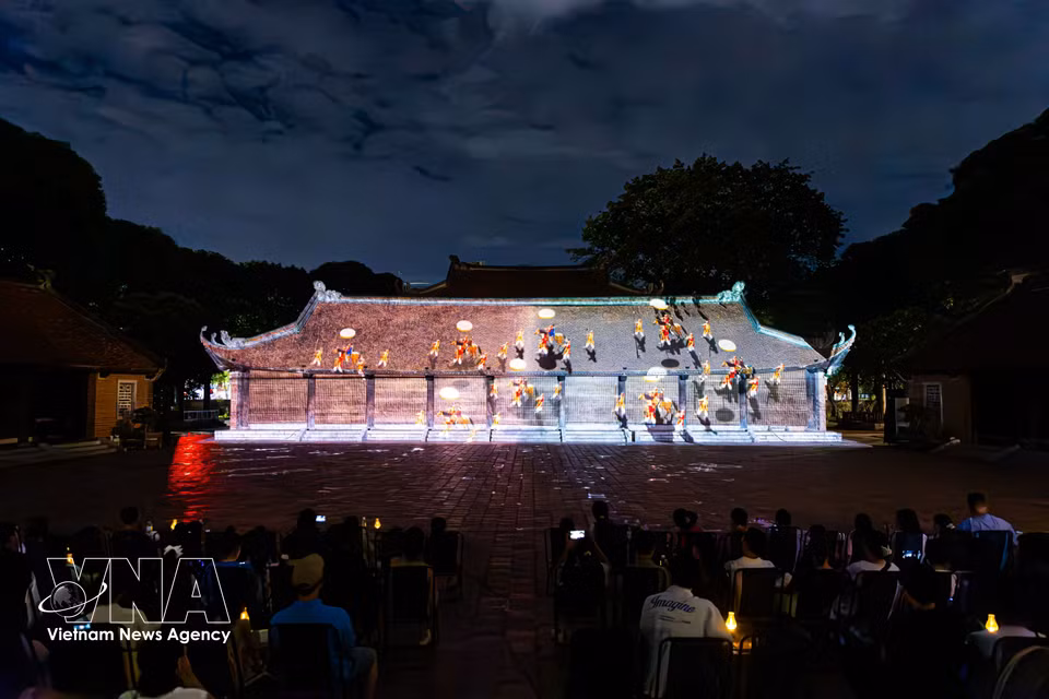 A modern 3D mapping display projected onto the ancient architecture of the Temple of Literature, depicting the journey of Vietnamese education before a large audience. (Photo: Published by VNA)