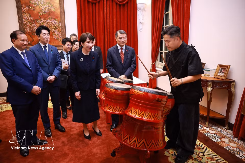 Japanese Prime Minister Takaichi Sanae watches a Vietnamese artist perform traditional Vietnamese drumming. (Photo: VNA)