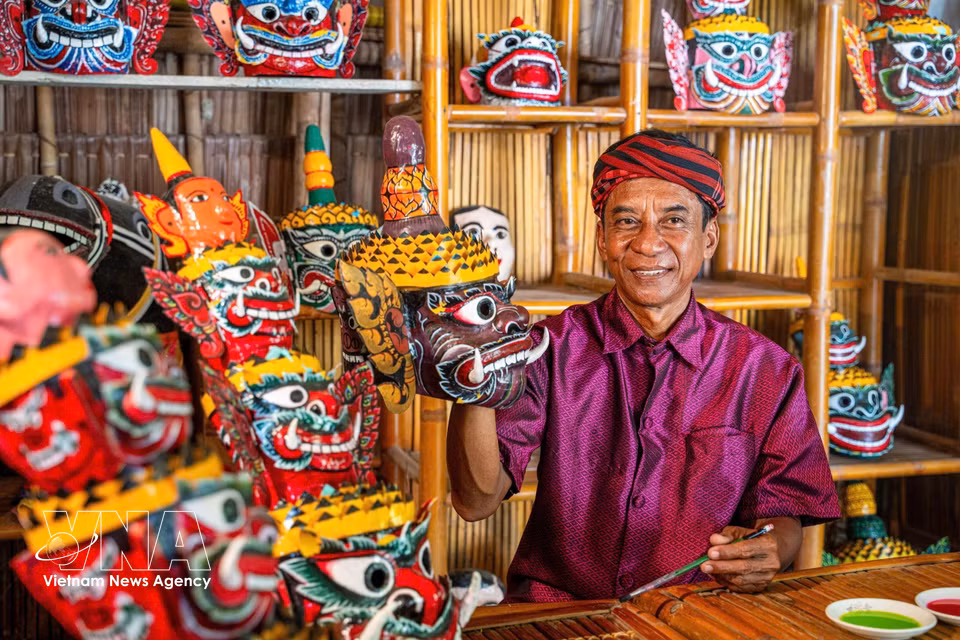 Meritorious Artisan Kim Manh, 62, from Ta Cu commune, Vinh Long province, crafts traditional masks for the Robam dance. (Photo: VNA)