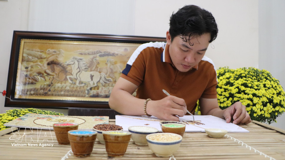 Khuu Tan Buu meticulously placing every grain to bring a rice painting to life. (Photo: VNA)